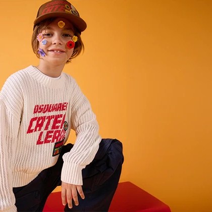 A boy wearing a stylish outfit with flowers on his face and a yellow background