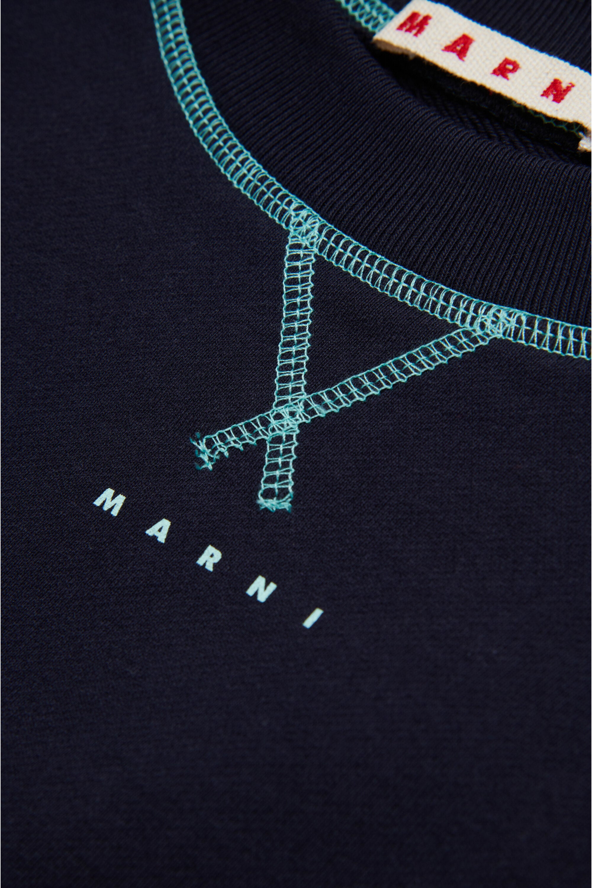 コントラストカラーのシームが施されたクルーネックのスウェットシャツ