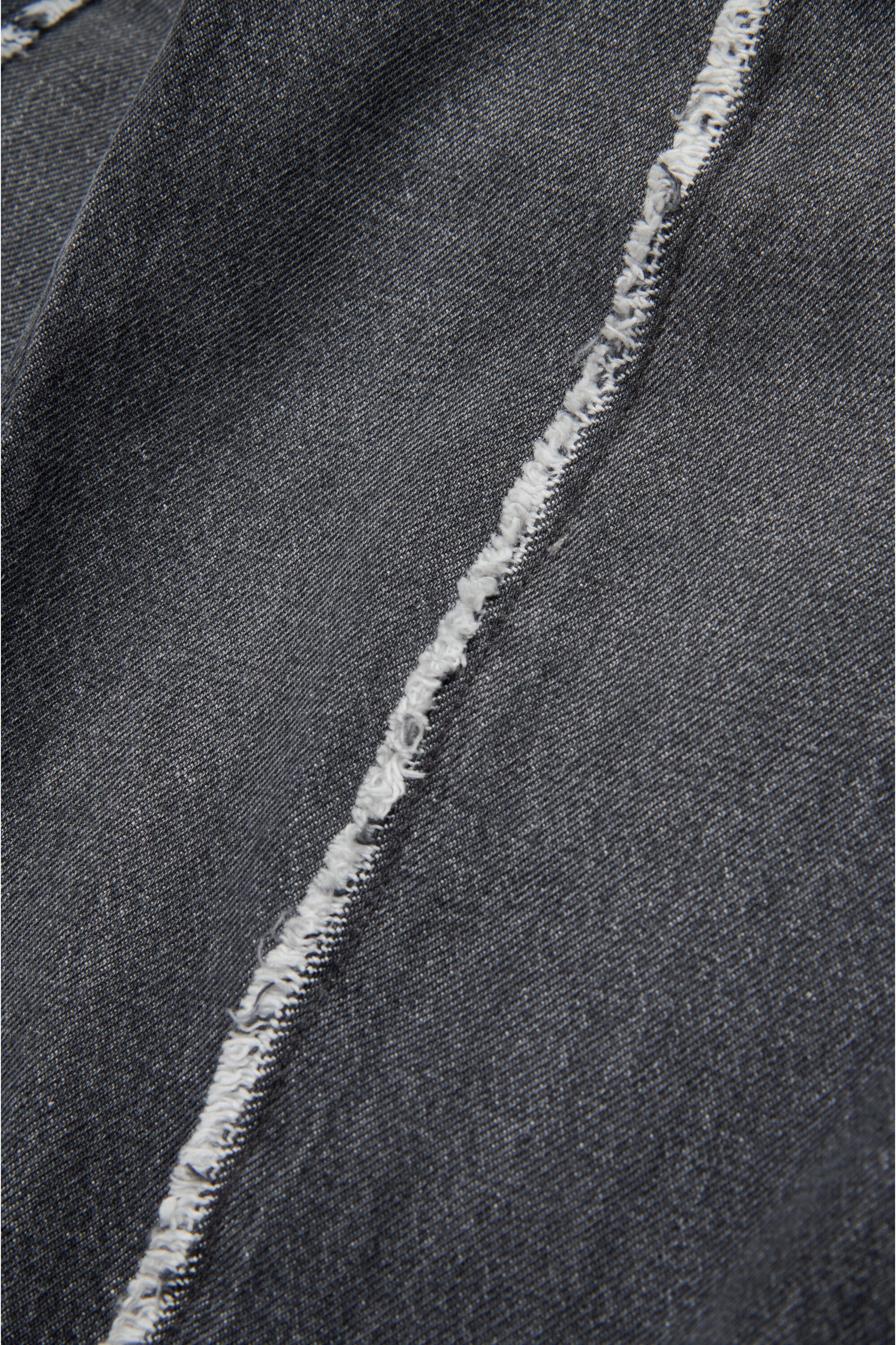 生成りのディテールのブラックジーンズ