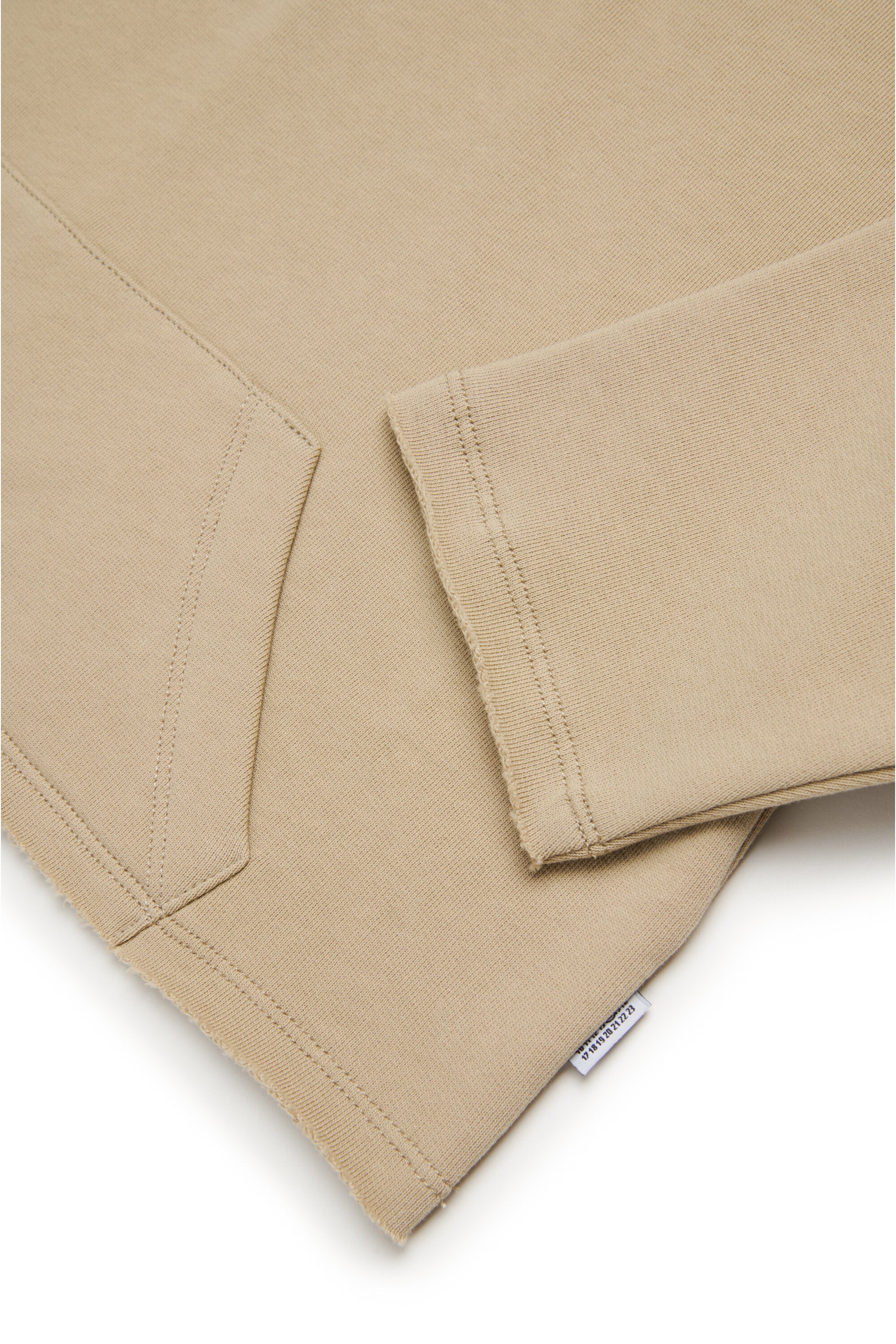 裾をカットしたフード付きスウェットシャツ