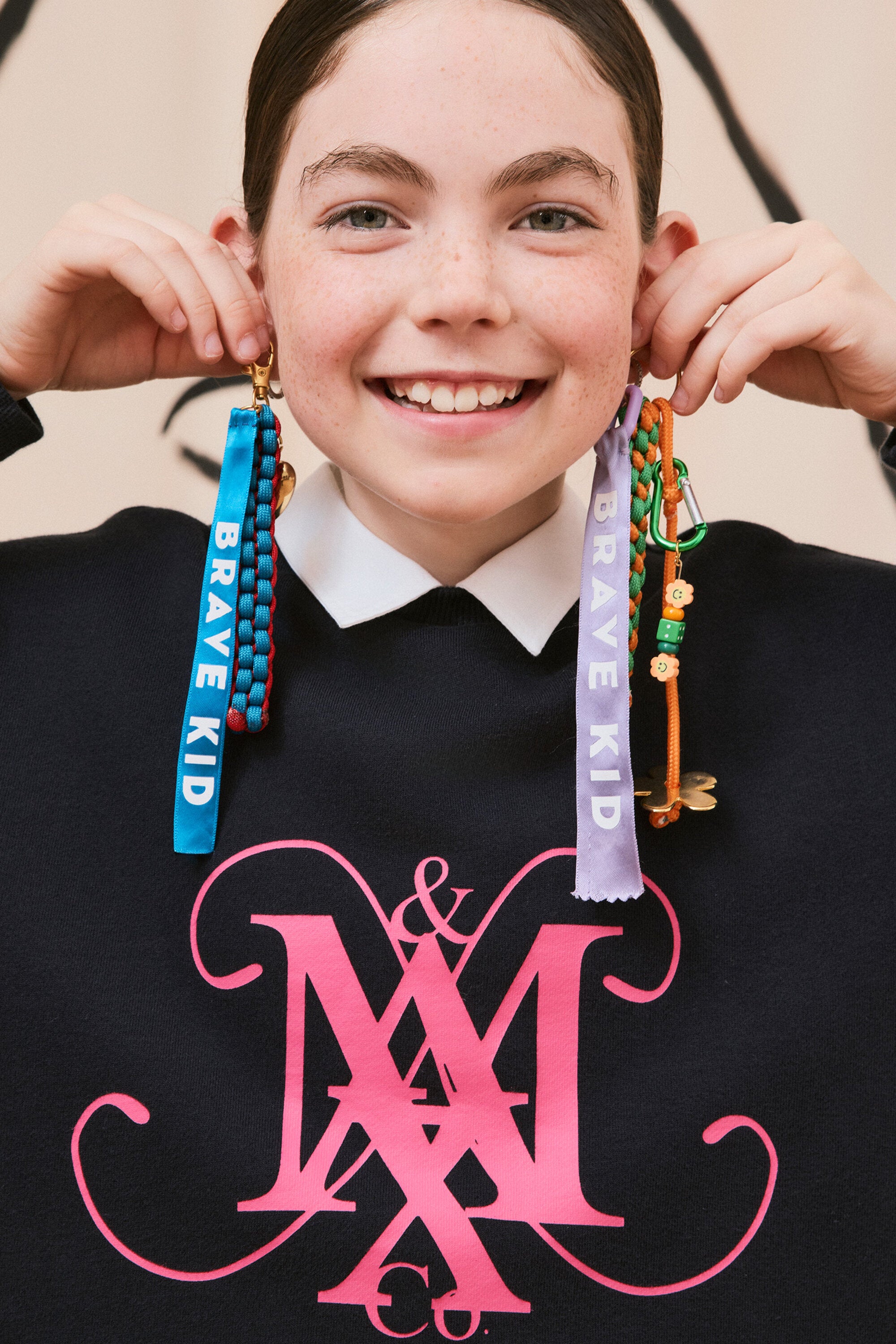 襟とエンブレムが付いたクルーネックスウェットシャツ