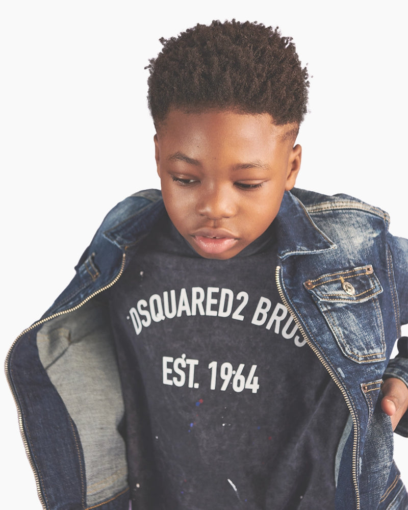 Child wearing a denim jacket over a Dsquared2 branded shirt on a white background